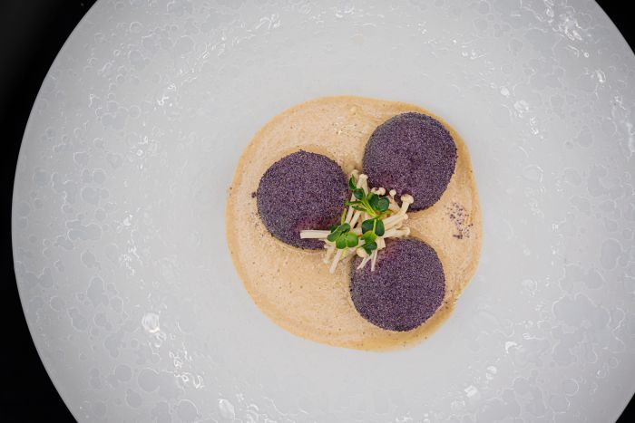 Sfera di patata blu di Starleggia, costine al lavec, funghi e consommè 